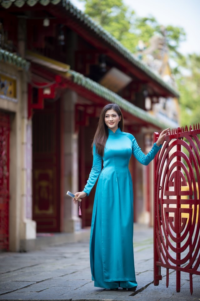 青のアオザイを着たベトナム人女性